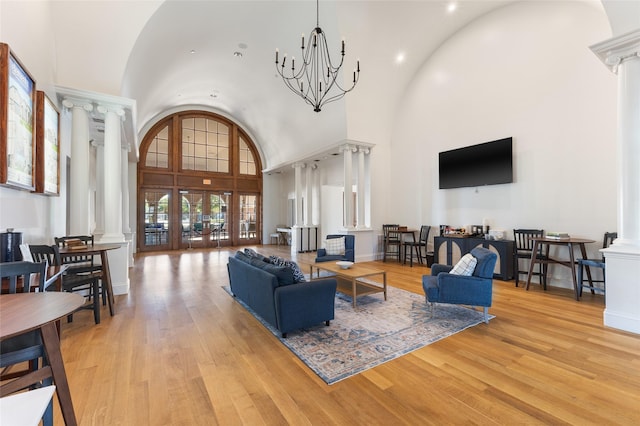 502 Austin Ln, Lavon, TX 75166 - living room with decorative columns, a towering ceiling, light wood finished floors, and a chandelier