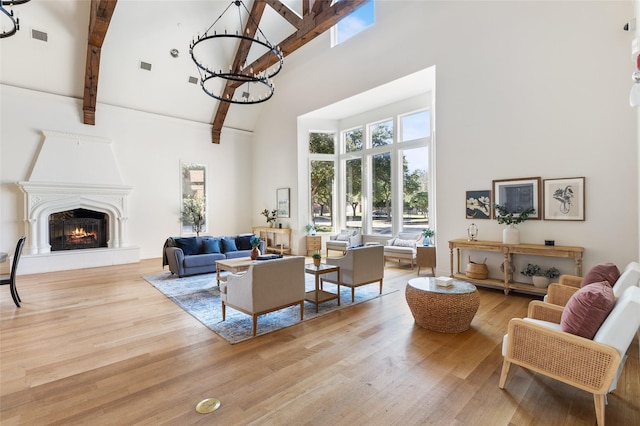502 Austin Ln, Lavon, TX 75166 - living room with high vaulted ceiling, a chandelier, beamed ceiling, a lit fireplace, and wood finished floors