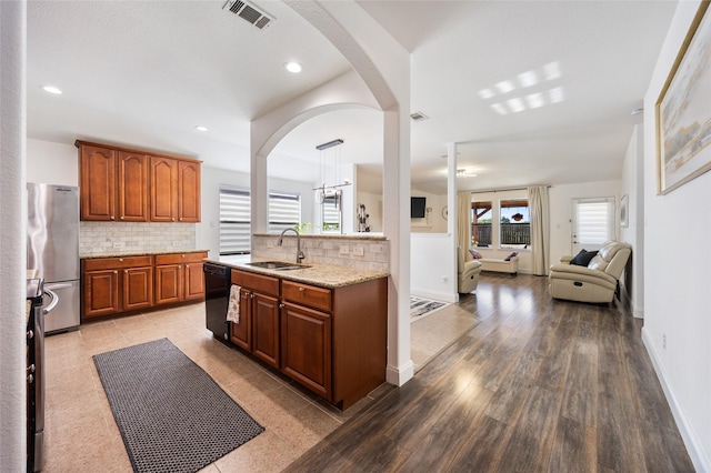 502 Austin Ln, Lavon, TX 75166 - kitchen featuring black dishwasher, freestanding refrigerator, tasteful backsplash, wood finished floors, and light stone counters