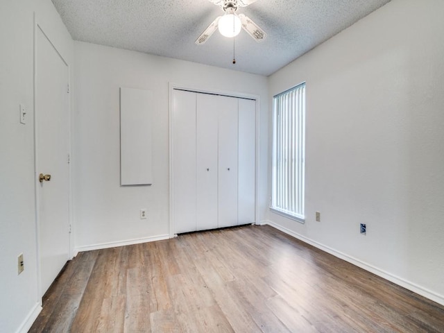 2705 Independence Dr, Mesquite, TX 75150 - unfurnished bedroom with wood finished floors, a textured ceiling, a closet, and ceiling fan