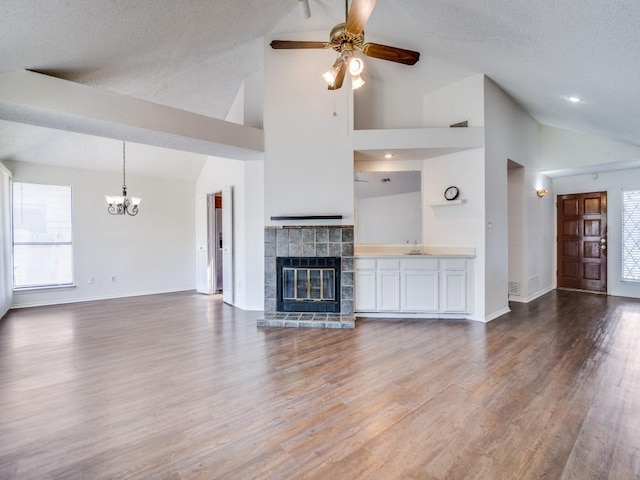 2705 Independence Dr, Mesquite, TX 75150 - unfurnished living room featuring a chandelier, a ceiling fan, a fireplace, healthy amount of natural light, and high vaulted ceiling