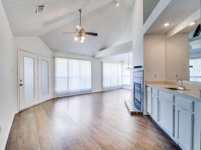 2705 Independence Dr, Mesquite, TX 75150 - kitchen featuring a ceiling fan, a fireplace with raised hearth, lofted ceiling, wood finished floors, and light countertops