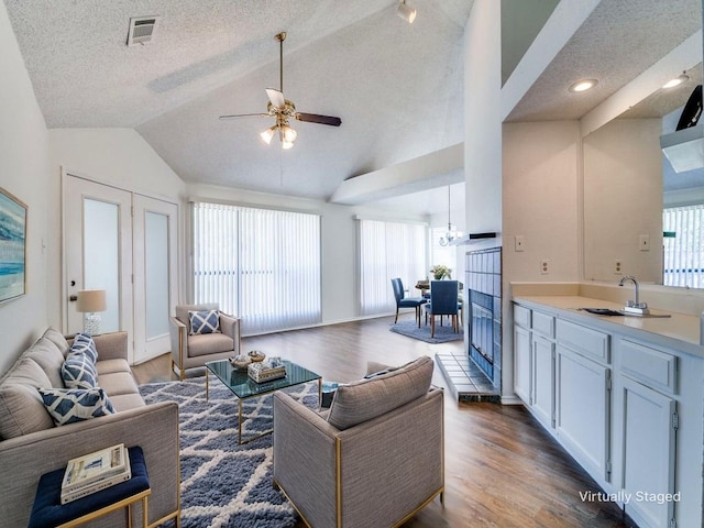 2705 Independence Dr, Mesquite, TX 75150 - living room with lofted ceiling, wood finished floors, a ceiling fan, a textured ceiling, and a chandelier