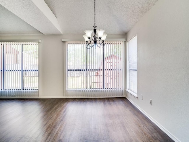 2705 Independence Dr, Mesquite, TX 75150 - unfurnished dining area with a textured ceiling, dark wood-type flooring, a chandelier, healthy amount of natural light, and a textured wall