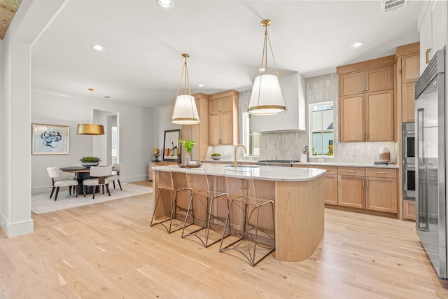 4532 Terroir Dr, Fort Worth, TX 76126 - kitchen with backsplash, an island with sink, a breakfast bar area, light wood-style flooring, and recessed lighting