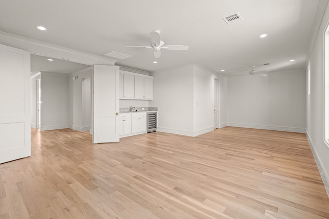 4532 Terroir Dr, Fort Worth, TX 76126 - unfurnished living room featuring a ceiling fan, beverage cooler, ornamental molding, recessed lighting, and light wood-type flooring