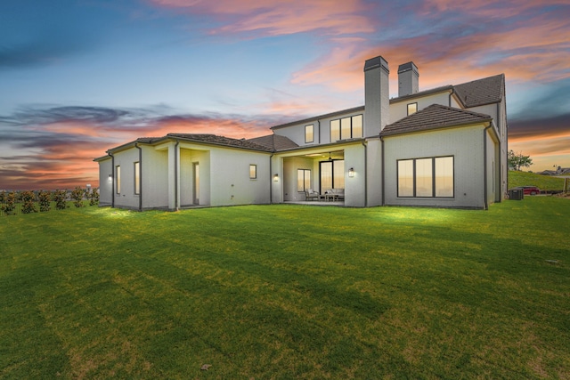 4532 Terroir Dr, Fort Worth, TX 76126 - back of house at dusk with a chimney, a lawn, and a patio area