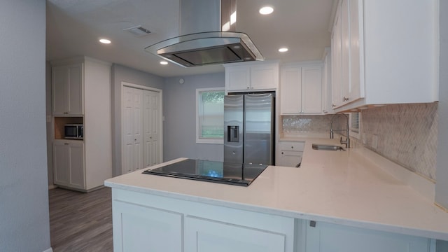 1619 Baylor Ave, Waco, TX 76706 - kitchen with appliances with stainless steel finishes, island exhaust hood, backsplash, a peninsula, and recessed lighting