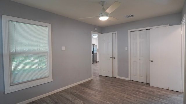 1619 Baylor Ave, Waco, TX 76706 - unfurnished bedroom with stainless steel fridge, wood finished floors, a ceiling fan, and two closets