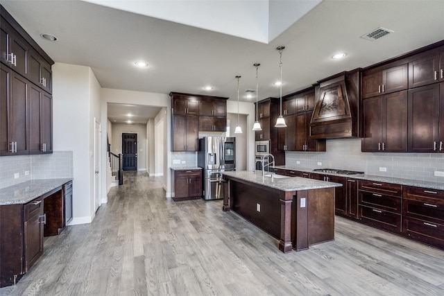 6105 Horsetail Dr, Mckinney, TX 75071 - kitchen with stainless steel appliances, tasteful backsplash, premium range hood, light wood-type flooring, and recessed lighting