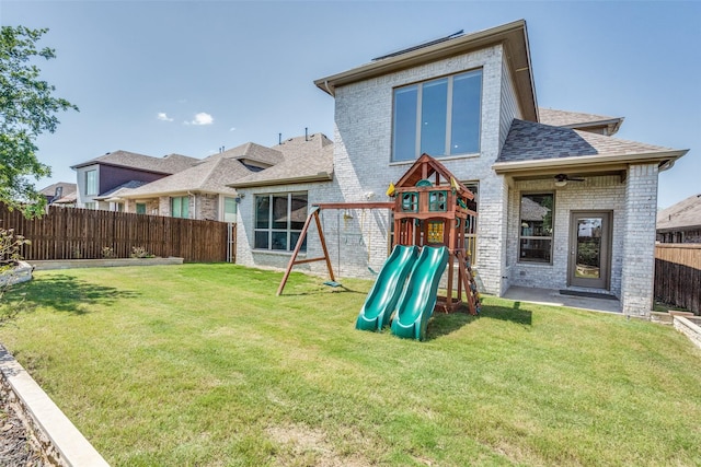 6105 Horsetail Dr, Mckinney, TX 75071 - rear view of property with brick siding, a playground, a fenced backyard, and a shingled roof