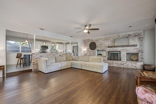 1203 Woodridge Cir, Euless, TX 76040 - living area with ceiling fan, wood finished floors, a fireplace, and brick wall