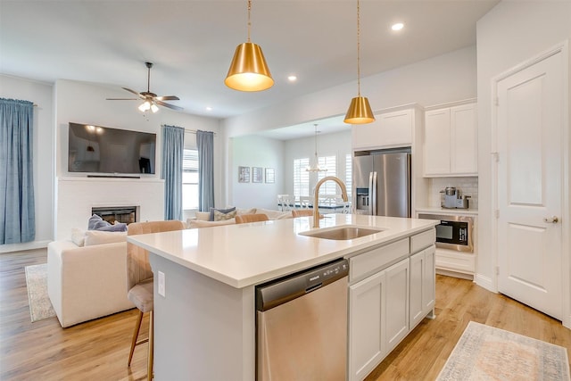 113 Observation Dr W, Aledo, TX 76008 - kitchen featuring stainless steel appliances, open floor plan, a brick fireplace, a kitchen island with sink, and a ceiling fan