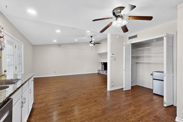 3302 Janwood Ln, Garland, TX 75044 - unfurnished living room with vaulted ceiling, a fireplace with raised hearth, ceiling fan, dark wood-style floors, and recessed lighting