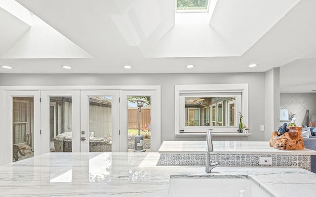 6005 Costera Ln, Dallas, TX 75248 - kitchen featuring recessed lighting, a skylight, light stone counters, and french doors