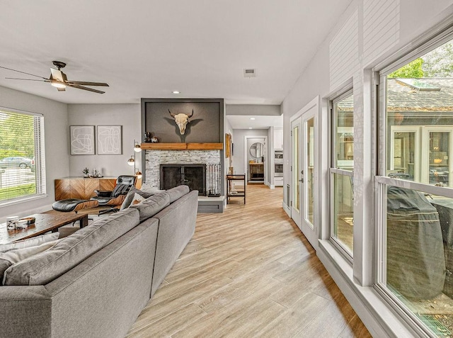 6005 Costera Ln, Dallas, TX 75248 - living area with healthy amount of natural light, light wood-style flooring, a fireplace, and ceiling fan