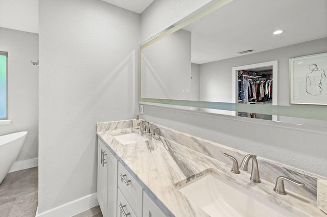6005 Costera Ln, Dallas, TX 75248 - bathroom with double vanity, a soaking tub, and a spacious closet