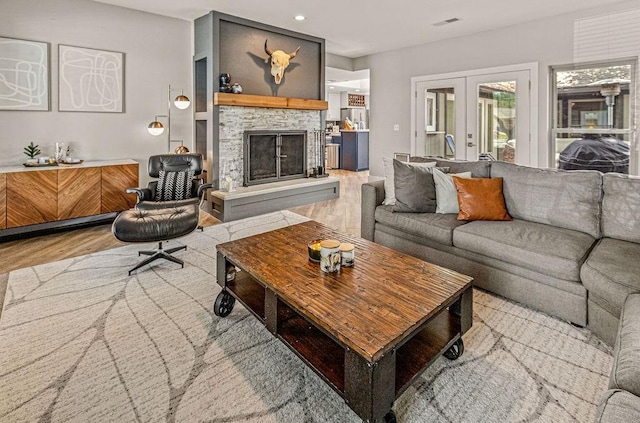 6005 Costera Ln, Dallas, TX 75248 - living area with wood finished floors, french doors, a stone fireplace, and recessed lighting