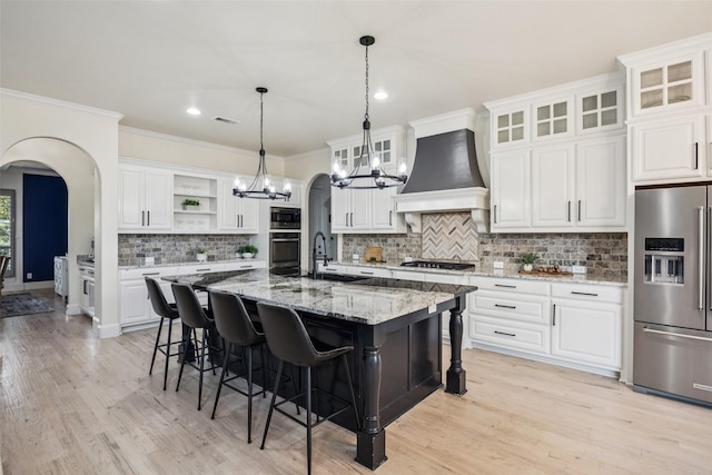 1030 Double B Trl, Prosper, TX 75078 - kitchen featuring appliances with stainless steel finishes, custom range hood, open shelves, arched walkways, and a chandelier