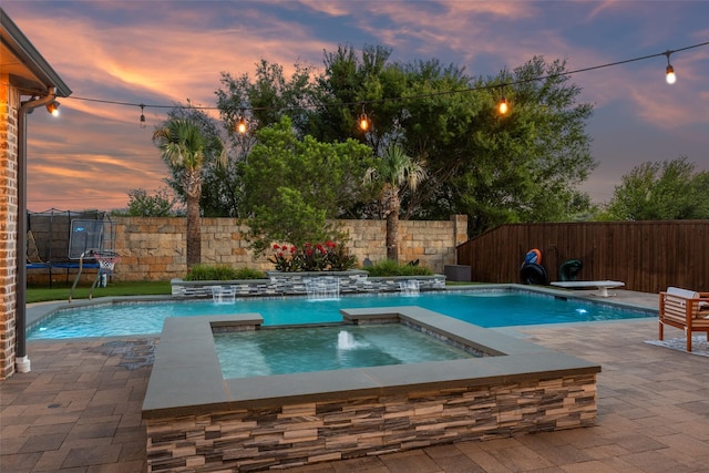 1030 Double B Trl, Prosper, TX 75078 - pool at dusk featuring a trampoline, a fenced backyard, an in-ground hot tub, and a patio