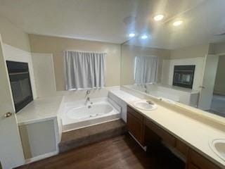 11805 Eloise Dr, Balch Springs, TX 75180 - full bathroom with a glass covered fireplace, double vanity, wood finished floors, and a garden tub