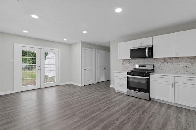 4118 Princeton Dr, Garland, TX 75042 - kitchen featuring stainless steel range with gas stovetop, wood finished floors, tasteful backsplash, light countertops, and white cabinets