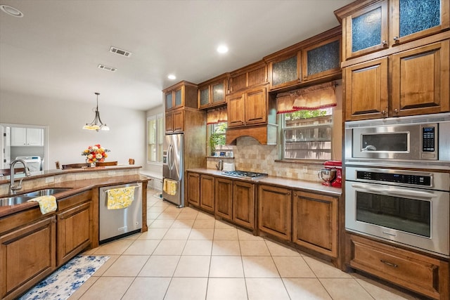 1911 Saddlehorn Ln, Mansfield, TX 76063 - kitchen with stainless steel appliances, brown cabinets, light tile patterned floors, and recessed lighting