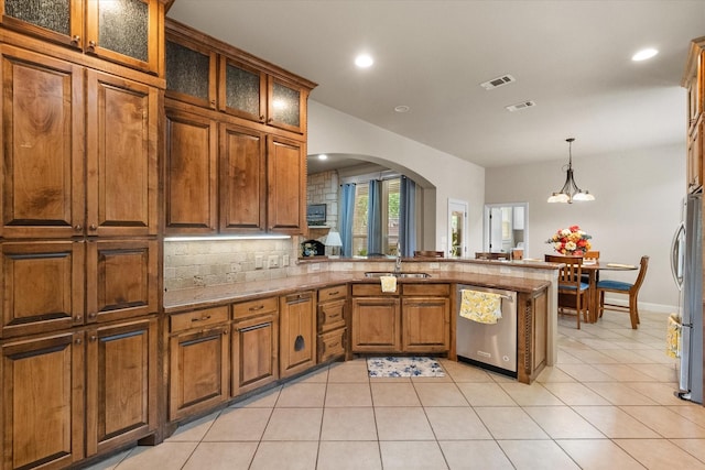 1911 Saddlehorn Ln, Mansfield, TX 76063 - kitchen featuring stainless steel appliances, a peninsula, arched walkways, brown cabinets, and a chandelier