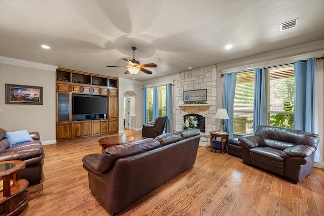 1911 Saddlehorn Ln, Mansfield, TX 76063 - living area featuring crown molding, a stone fireplace, light wood-style flooring, ceiling fan, and recessed lighting