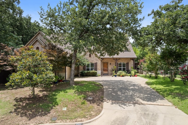 1911 Saddlehorn Ln, Mansfield, TX 76063 - obstructed view of property featuring brick siding and curved driveway