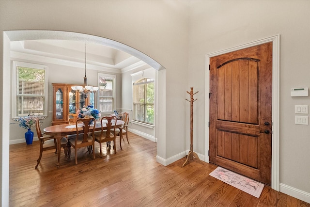 1911 Saddlehorn Ln, Mansfield, TX 76063 - entrance foyer with a raised ceiling, arched walkways, light wood-style floors, a chandelier, and ornamental molding