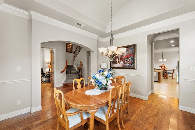 1911 Saddlehorn Ln, Mansfield, TX 76063 - dining space with stairs, a chandelier, arched walkways, light wood-type flooring, and crown molding