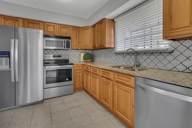 4748 Old Bent Tree Ln Unit 701, Dallas, TX 75287 - kitchen featuring appliances with stainless steel finishes, light stone counters, decorative backsplash, light tile patterned flooring, and brown cabinetry