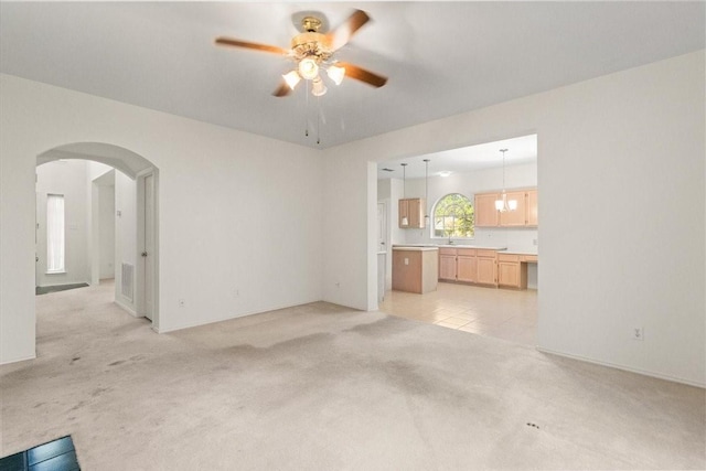 1100 Bellingham Pl, Arlington, TX 76001 - unfurnished living room with light carpet, ceiling fan, and arched walkways