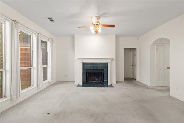 1100 Bellingham Pl, Arlington, TX 76001 - unfurnished living room with ceiling fan, carpet floors, a tiled fireplace, and arched walkways