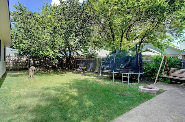 5905 Northfield Dr, Fort Worth, TX 76179 - fenced backyard with a trampoline, a fire pit, and a patio