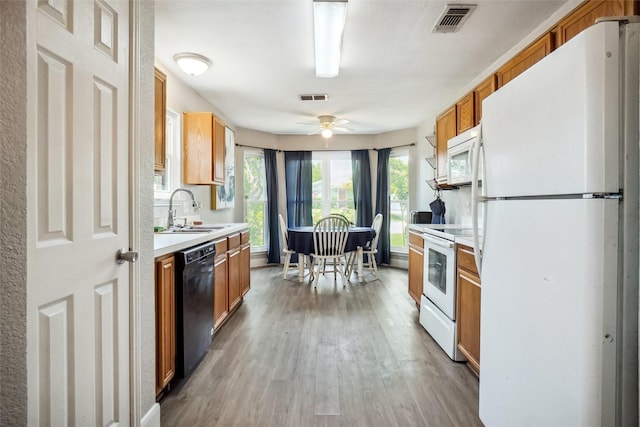 5905 Northfield Dr, Fort Worth, TX 76179 - kitchen with white appliances, light wood-style floors, light countertops, brown cabinetry, and a ceiling fan