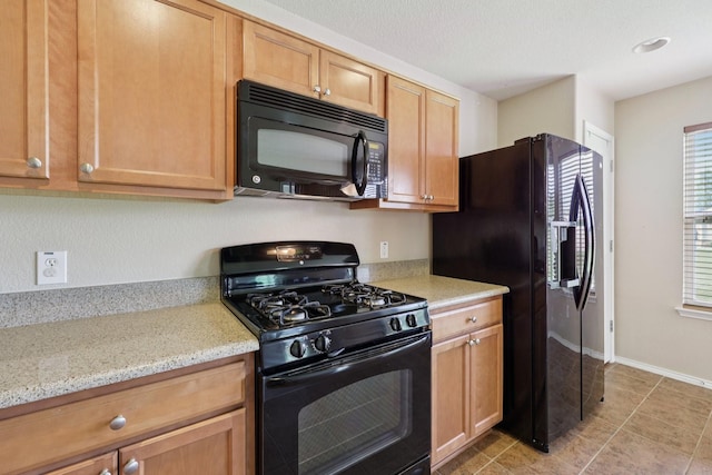 7850 Estancia Dr, Frisco, TX 75036 - kitchen featuring black appliances, light stone countertops, and light tile patterned floors