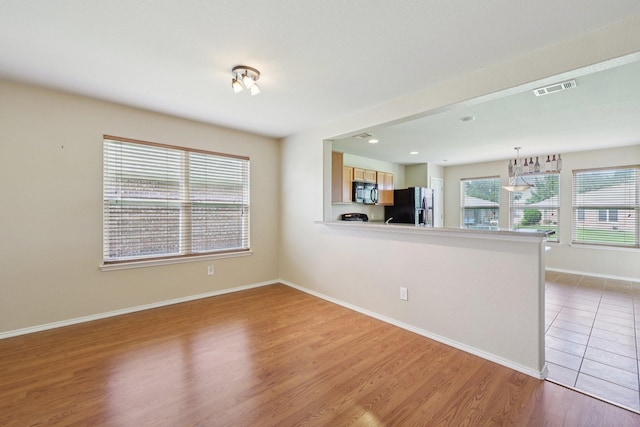 7850 Estancia Dr, Frisco, TX 75036 - unfurnished living room with light wood finished floors and baseboards