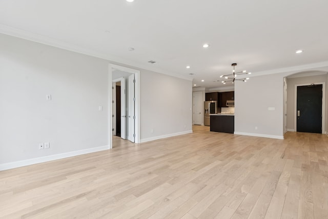 2300 Leonard St Unit 305, Dallas, TX 75201 - unfurnished living room with arched walkways, a chandelier, ornamental molding, recessed lighting, and light wood finished floors