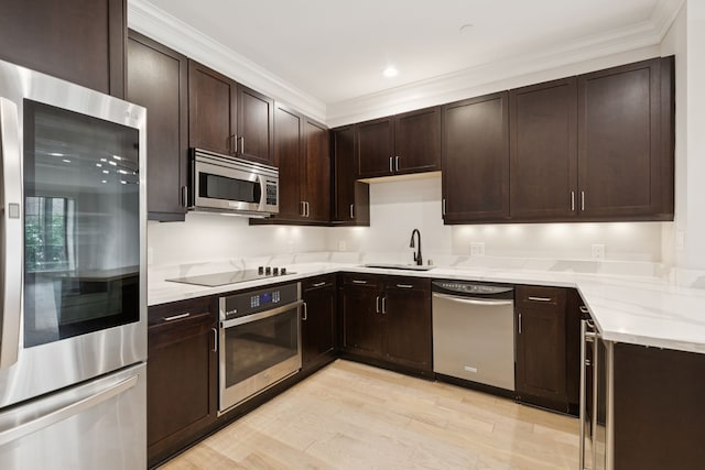 2300 Leonard St Unit 305, Dallas, TX 75201 - kitchen with stainless steel appliances, dark brown cabinetry, ornamental molding, light wood-type flooring, and light stone countertops