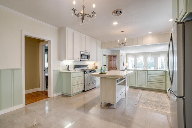 2012 Carleton Ave, Fort Worth, TX 76107 - kitchen featuring stainless steel appliances, a chandelier, light countertops, crown molding, and decorative backsplash