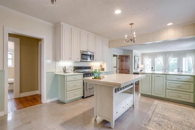 2012 Carleton Ave, Fort Worth, TX 76107 - kitchen featuring appliances with stainless steel finishes, a chandelier, crown molding, light countertops, and a kitchen island