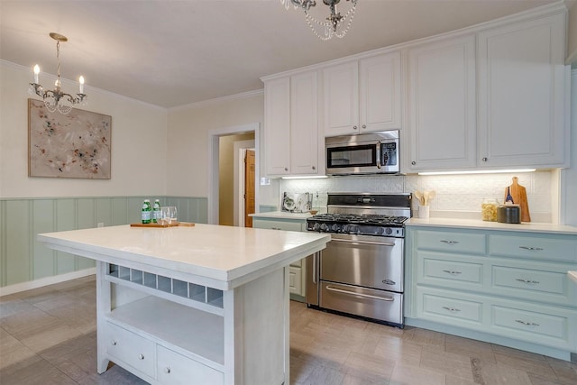 2012 Carleton Ave, Fort Worth, TX 76107 - kitchen with stainless steel appliances, a chandelier, light countertops, a wainscoted wall, and crown molding