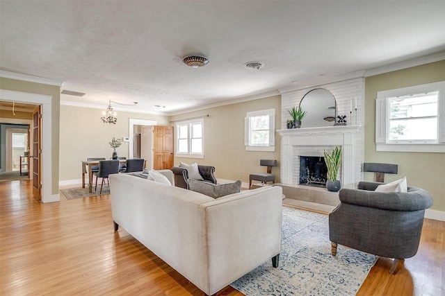 2012 Carleton Ave, Fort Worth, TX 76107 - living area with light wood finished floors, crown molding, a chandelier, and a fireplace