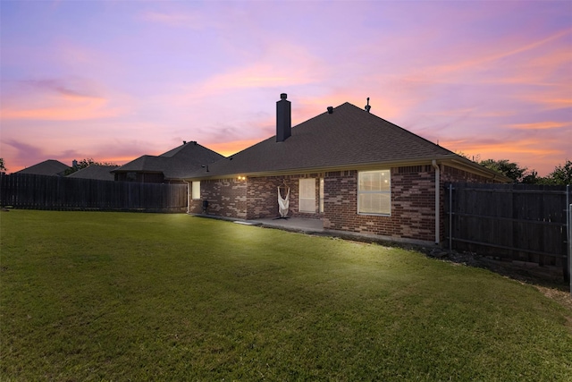 6308 Harold Creek Dr, Fort Worth, TX 76179 - back of house at dusk featuring a chimney, brick siding, a fenced backyard, and a patio area
