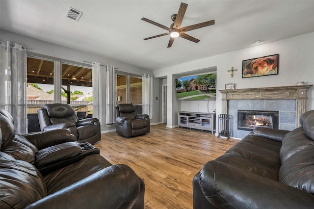 7305 Meadowwood Dr, Rowlett, TX 75089 - living area with ceiling fan, wood finished floors, and a tiled fireplace