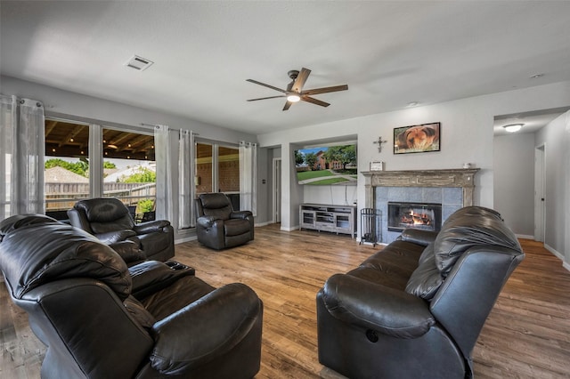 7305 Meadowwood Dr, Rowlett, TX 75089 - living room featuring ceiling fan, a tiled fireplace, and wood finished floors