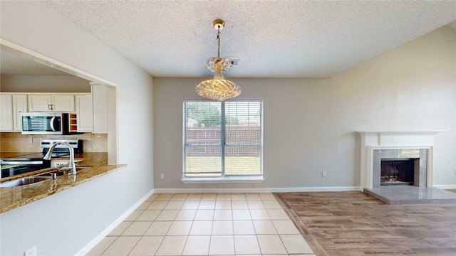 328 Antietam Way, Mesquite, TX 75149 - unfurnished dining area with a textured ceiling, a fireplace, and light tile patterned floors
