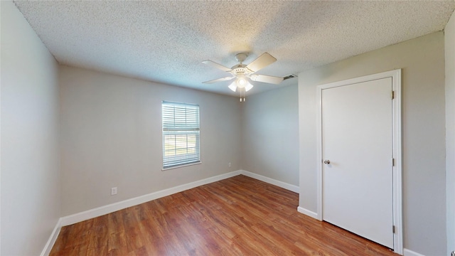 328 Antietam Way, Mesquite, TX 75149 - unfurnished bedroom featuring wood finished floors, a textured ceiling, and a ceiling fan